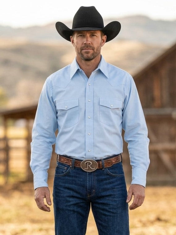 Man wearing solid light blue shirt by Flying R Ranchwear with two pockets and flaps and snap closures. Made in USA